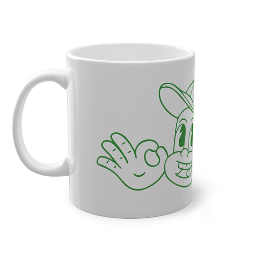 White mug with green cartoon character design on a white background